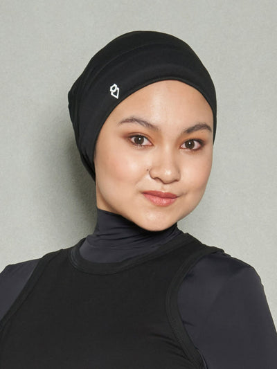 A close up shot of a woman wearing ZHOORA Sports Hijab. She is also wearing Demure Essential Long Sleeve Sports Bra and black women's workout top.