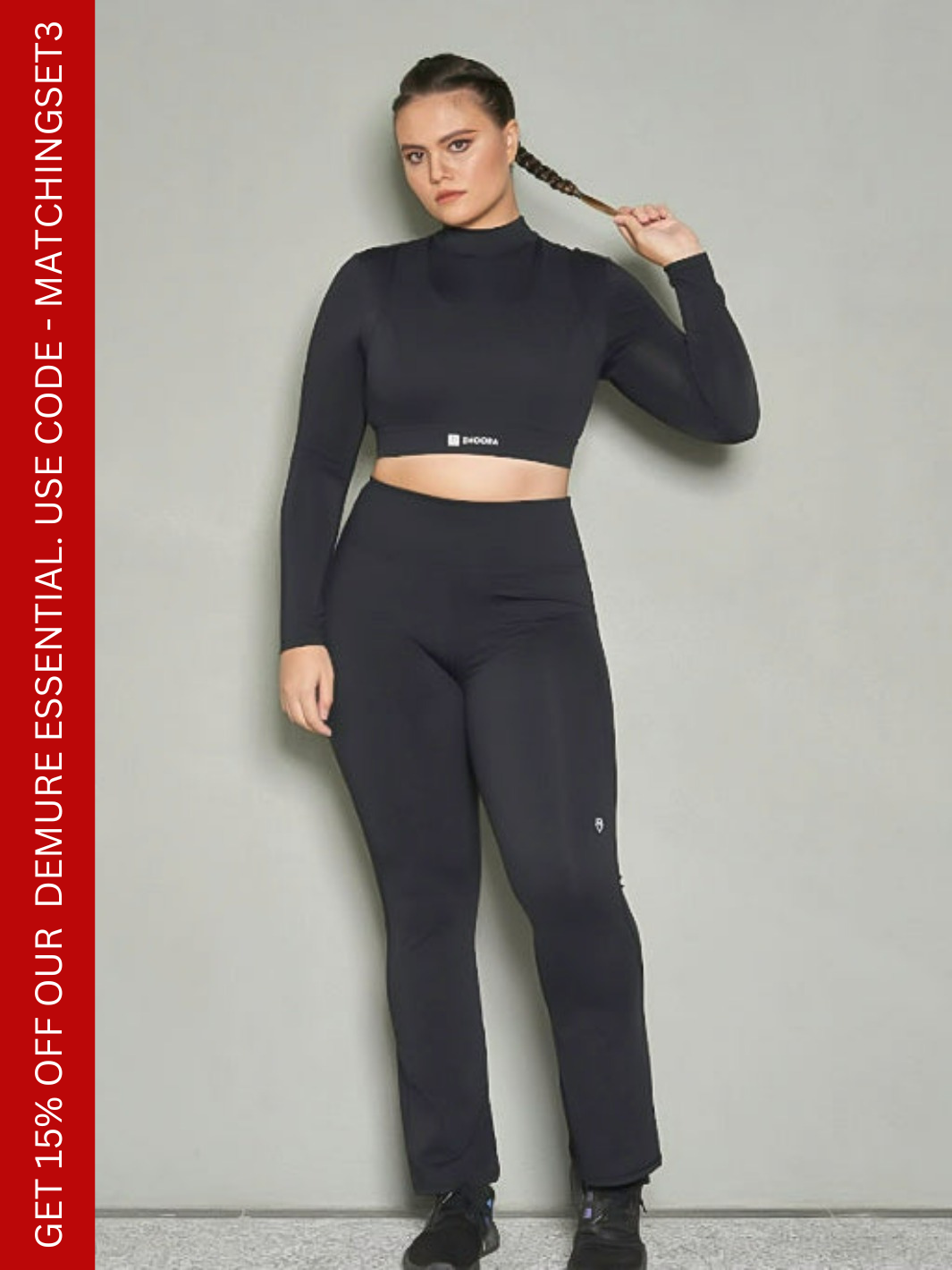 A shot of a woman wearing a matching set of black bootleg pants and long sleeves sports bra